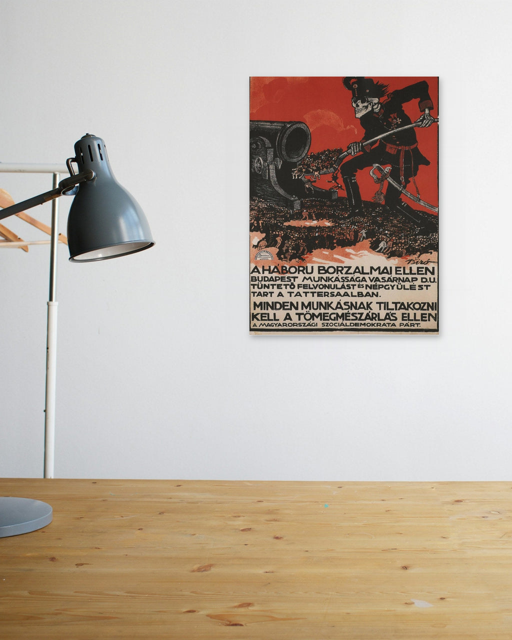 "A Háború Borzalmai Ellen" poster above a wooden desk