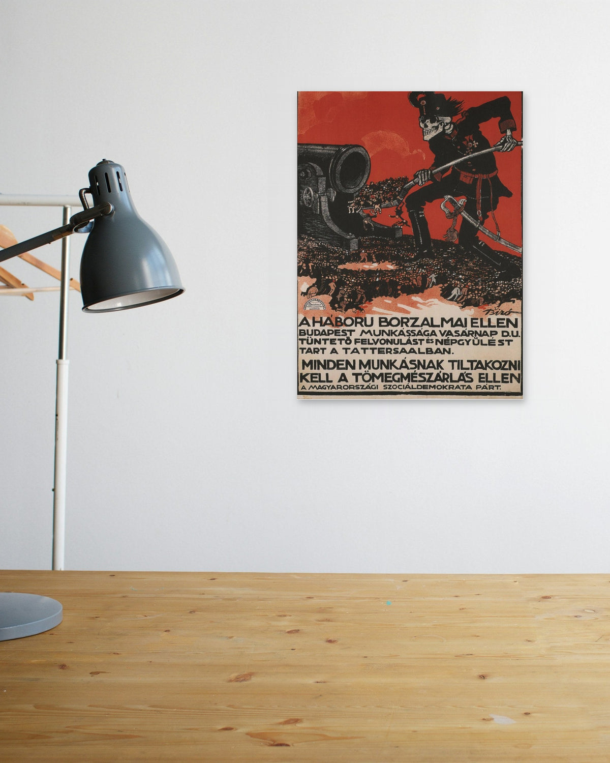"A Háború Borzalmai Ellen" poster above a wooden desk