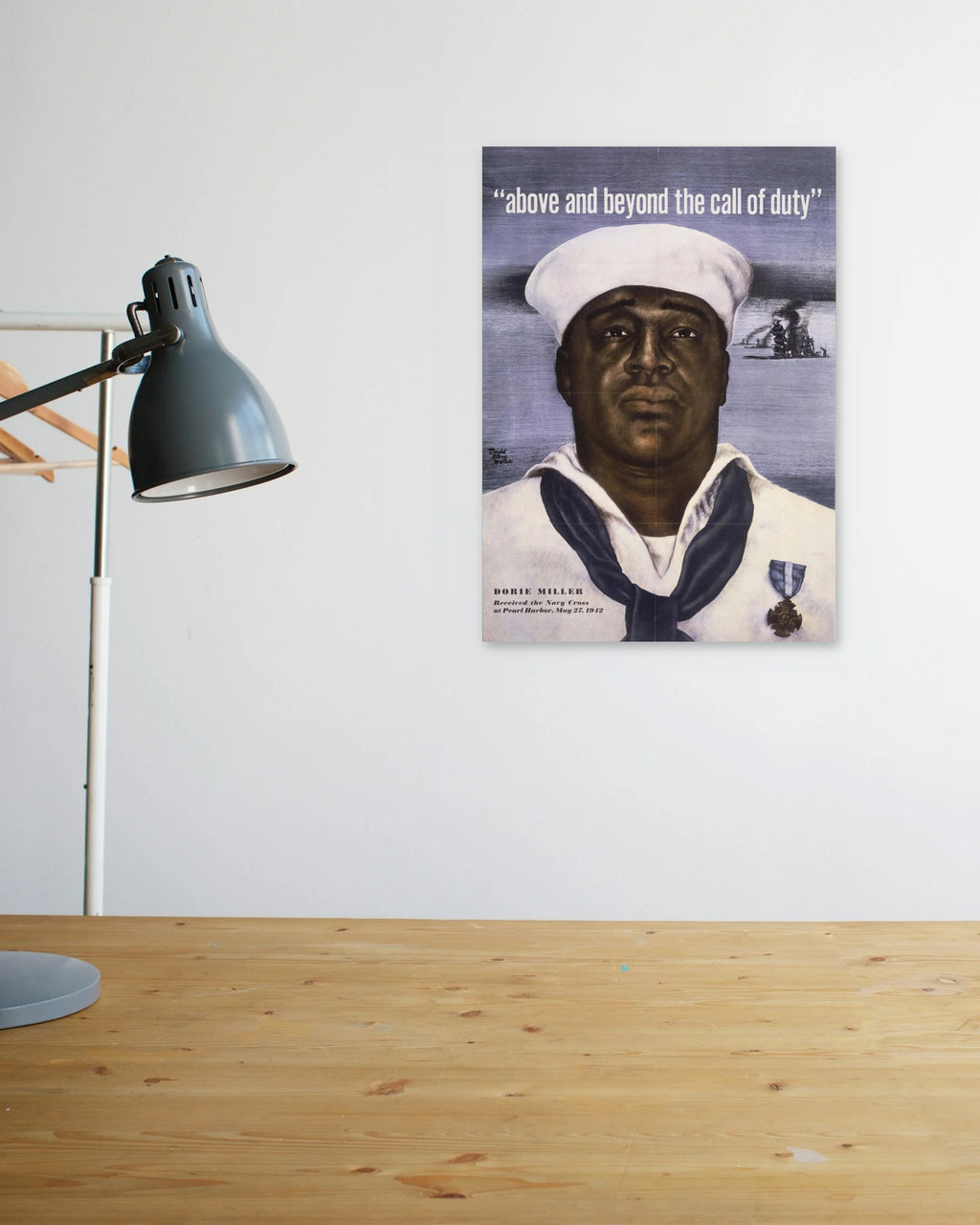 "Above and Beyond the Call of Duty" poster above a wooden desk