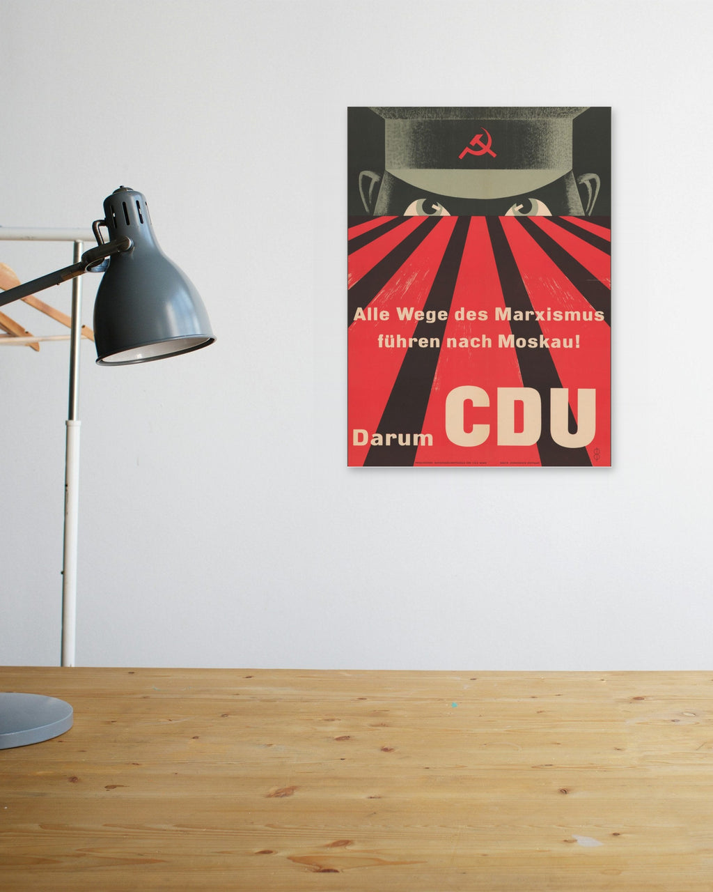 "All Roads of Marxism Lead to Moscow" poster above a wooden desk