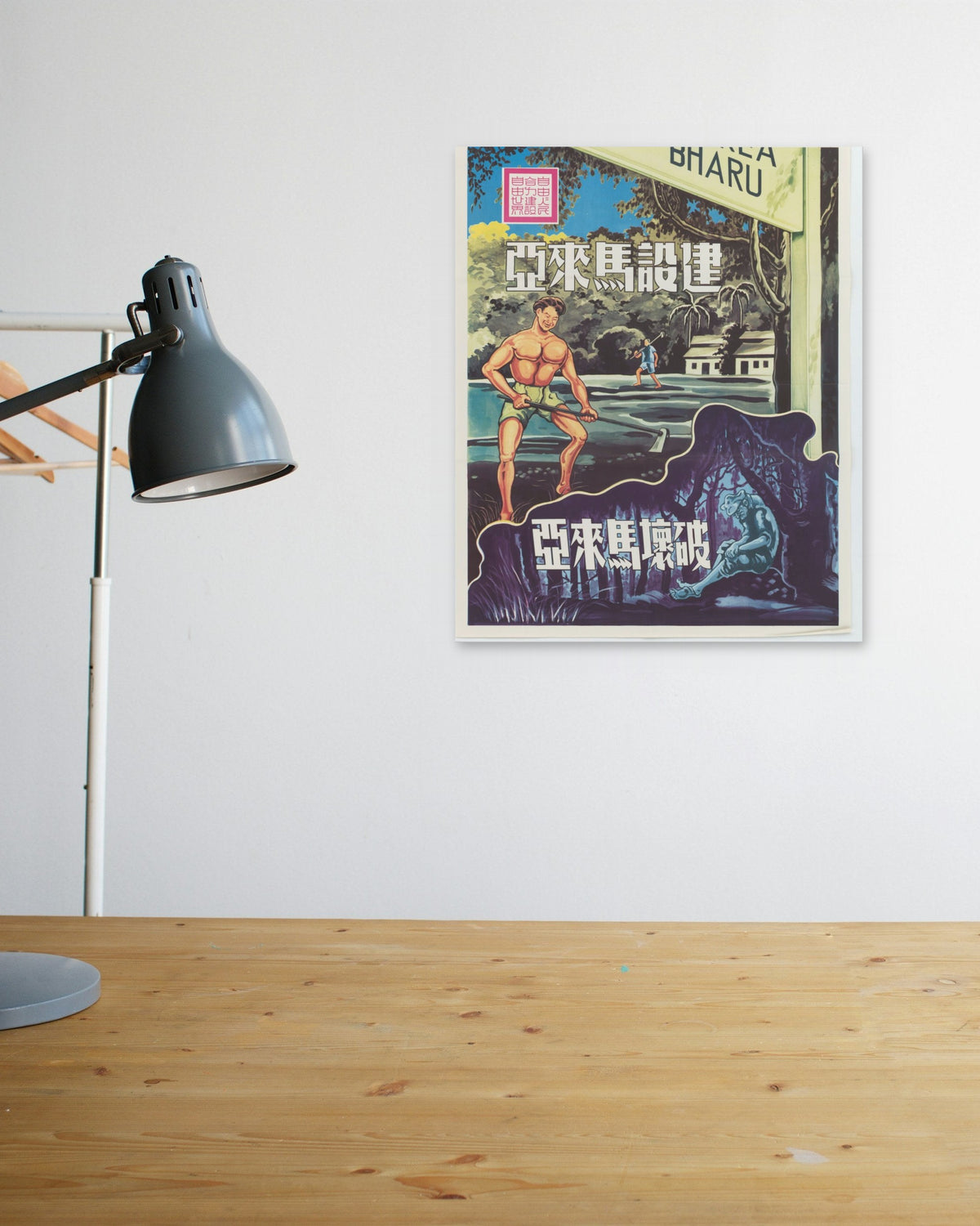 "Building & Destroying Malaya" poster above a wooden desk