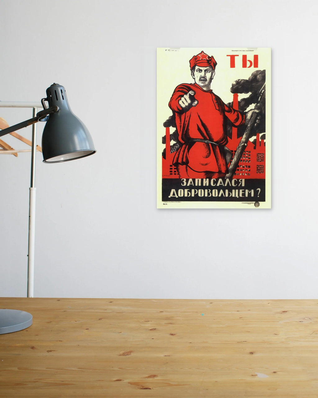 "Did You Volunteer?" poster above a wooden desk
