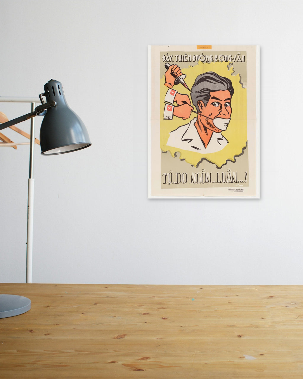 "Freedom of Speech in the Communist Paradise" poster above a wooden desk