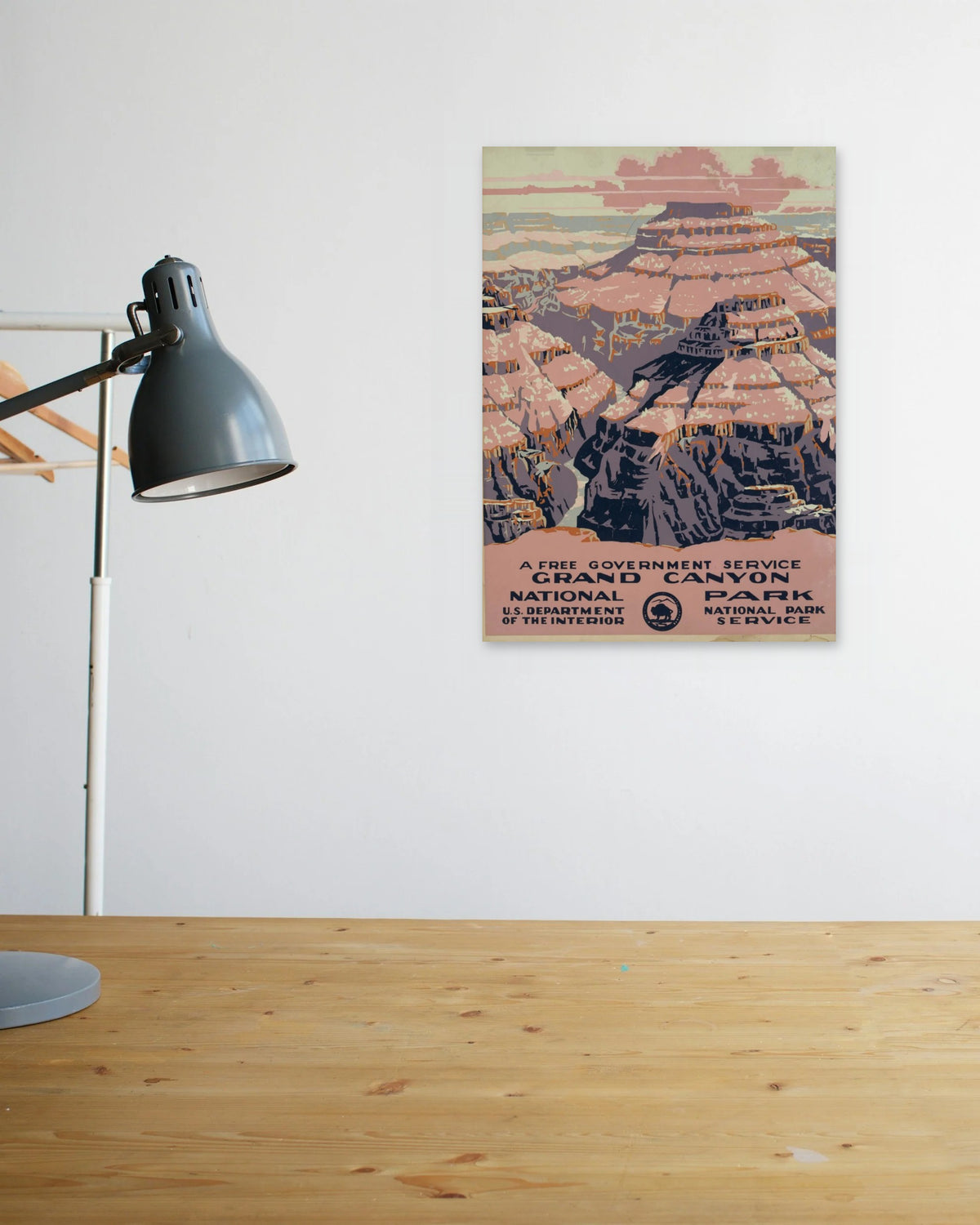 "Grand Canyon National Park" poster above a wooden desk