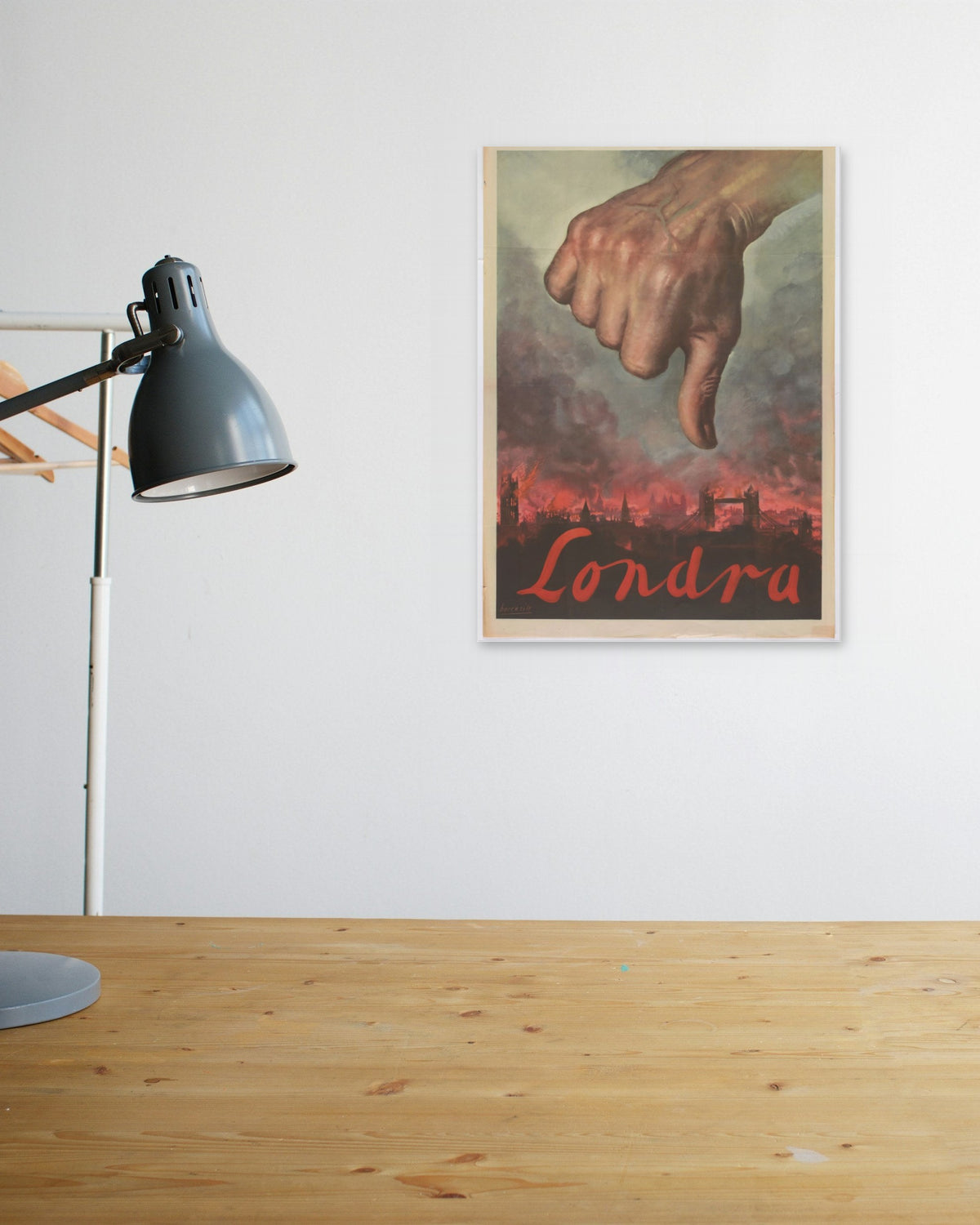 "Londra" poster above a wooden desk