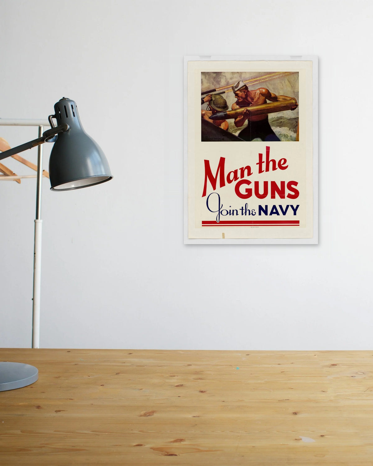 "Man the Guns! Join the Navy" poster above a wooden desk