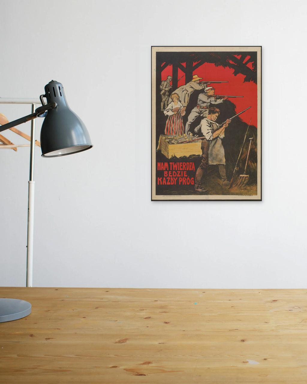 "Nam Twierdzą Będzie Każdy Próg!" poster above a wooden desk