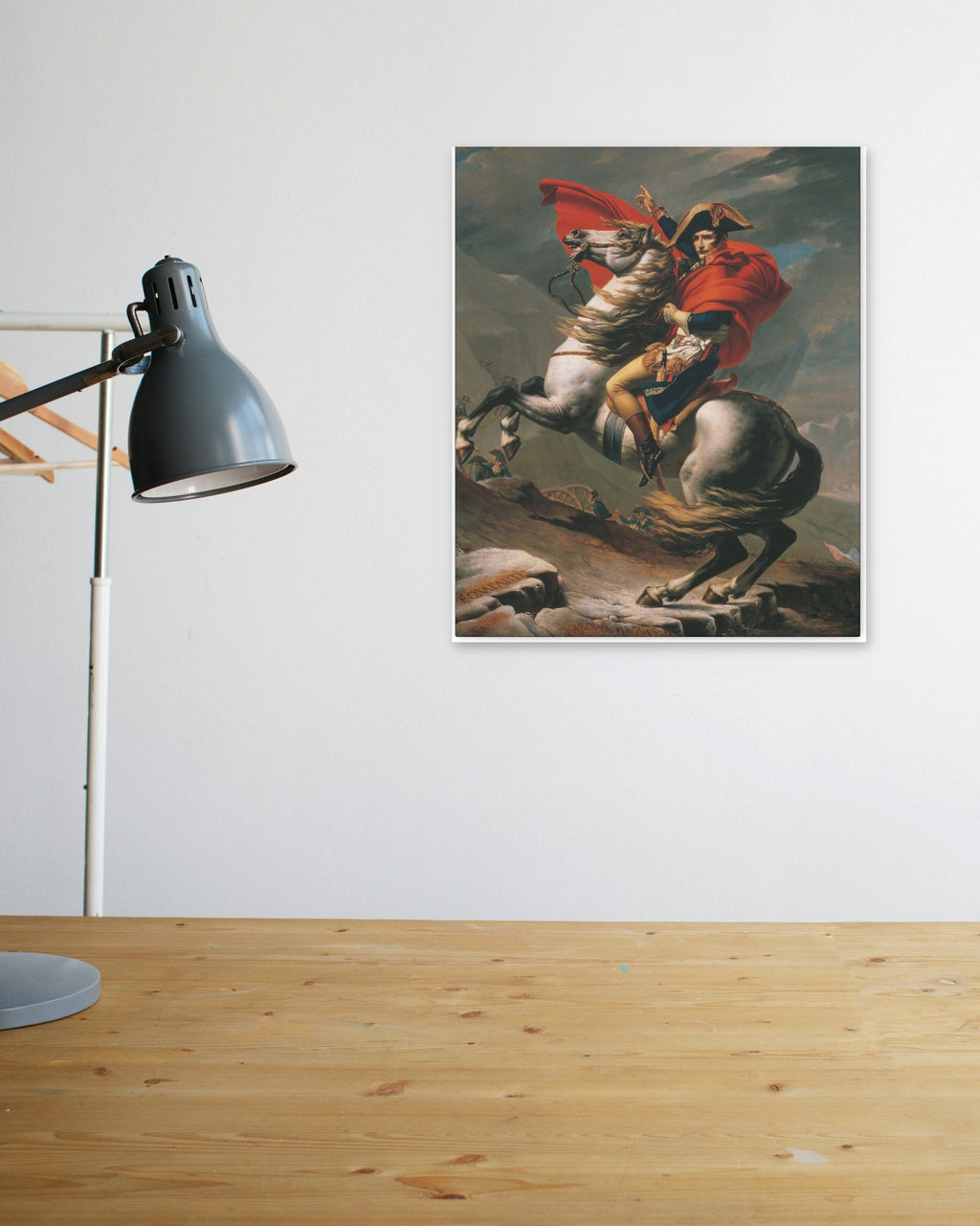 "Napoleon Crossing the Alps" poster above a wooden desk