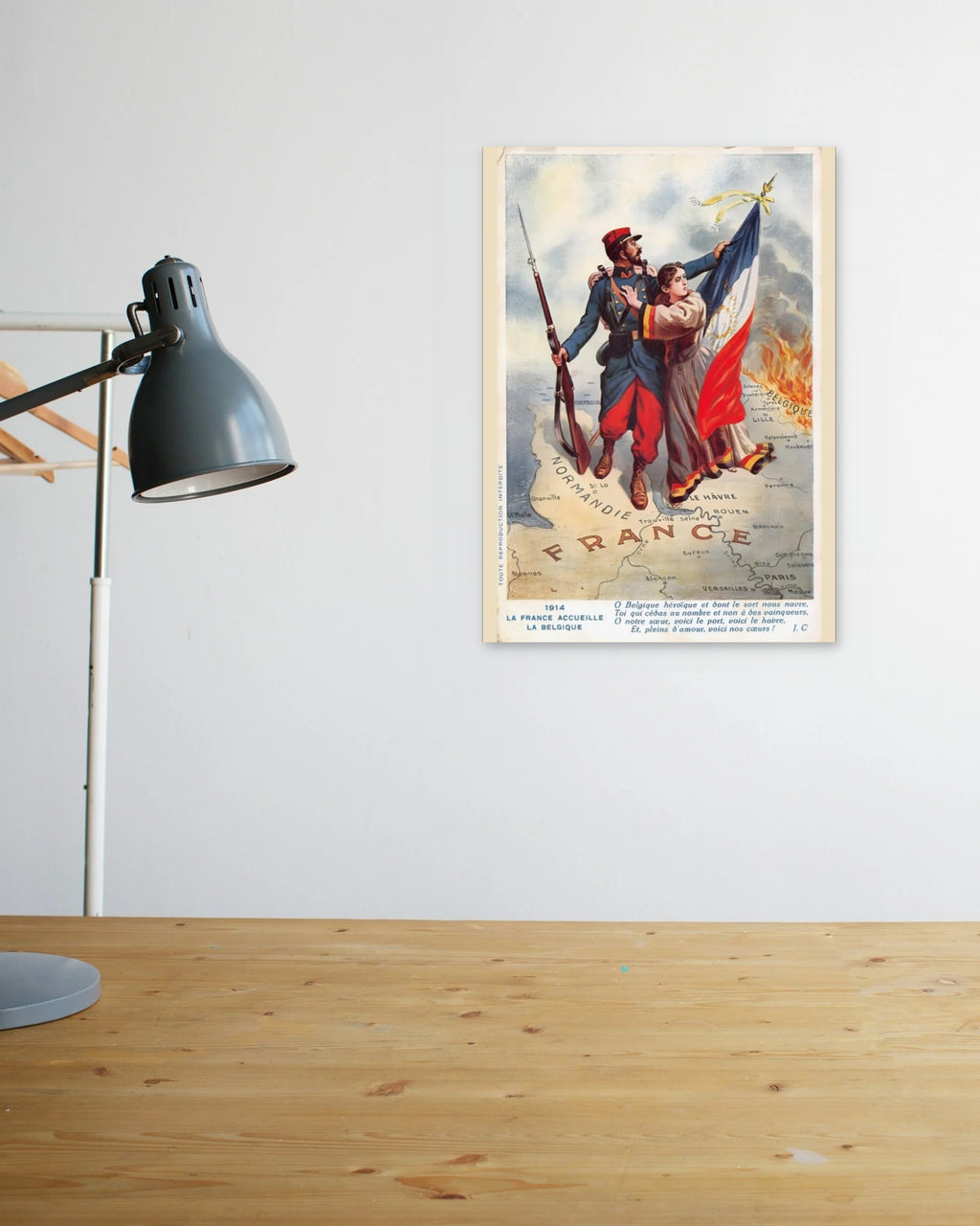 "O Heroic Belgium, Whose Fate Grieves Us" poster above a wooden desk
