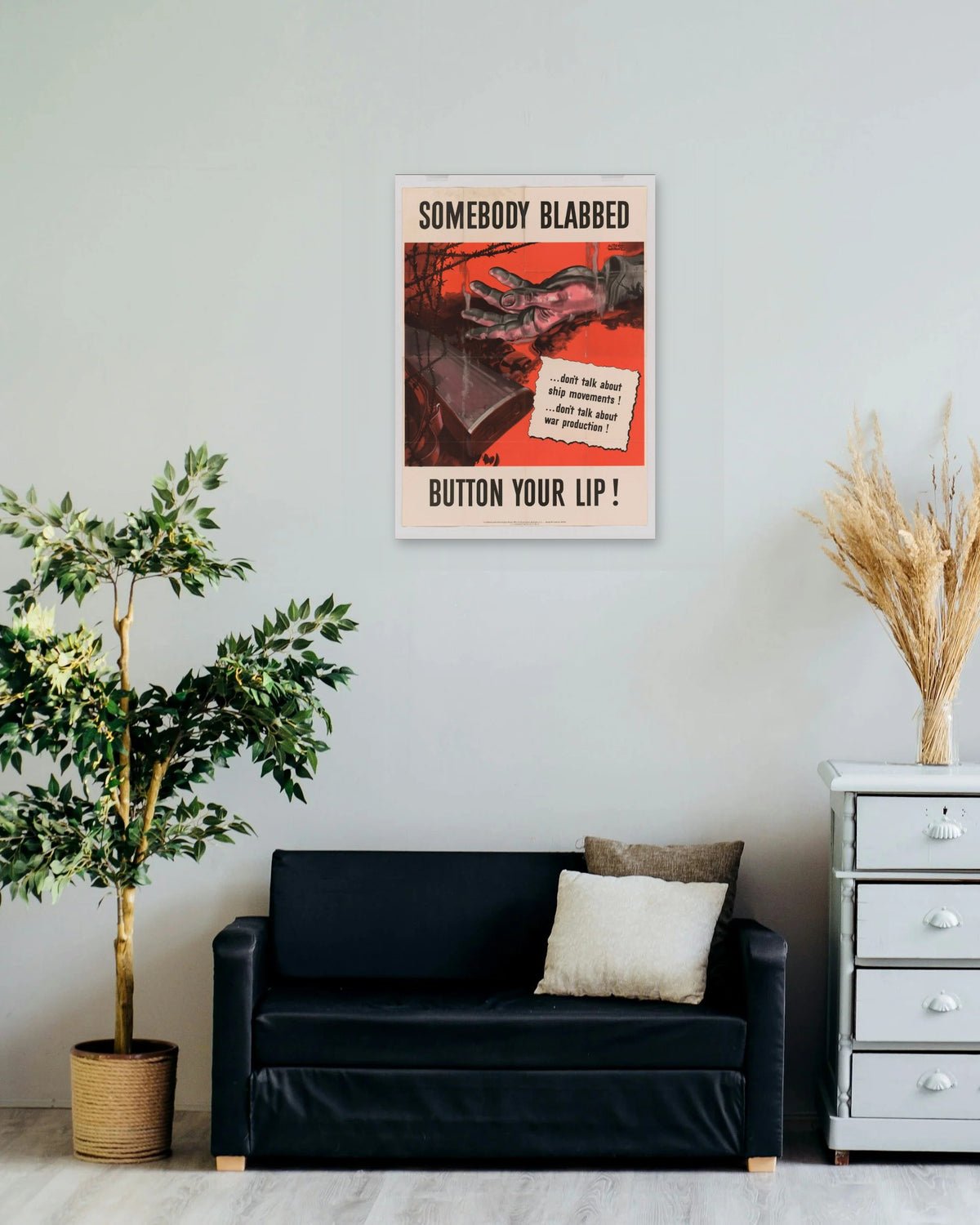 "Somebody Blabbed - Button Your Lip!" poster on a living room wall