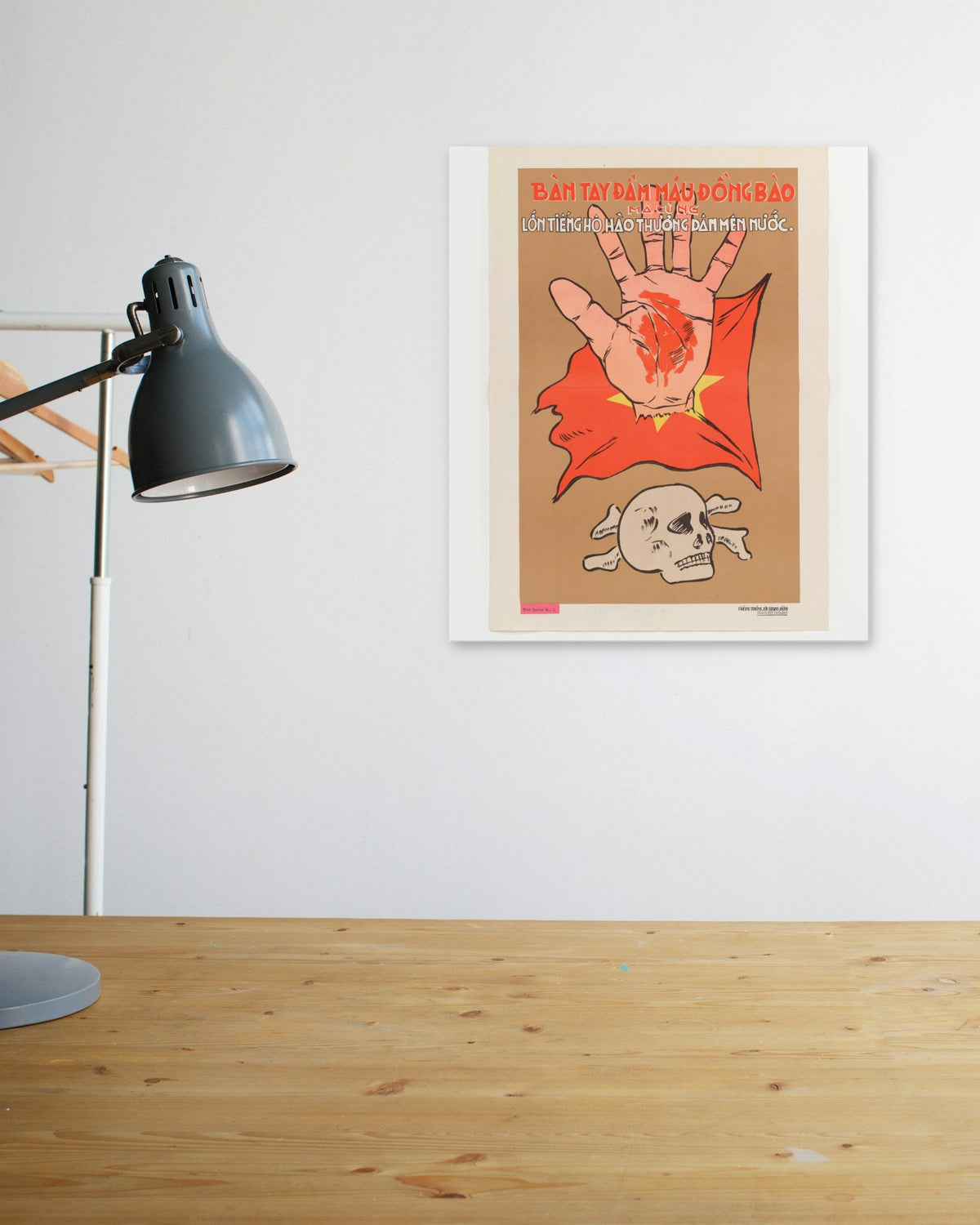 "The Bloodstained Hand" poster above a wooden desk