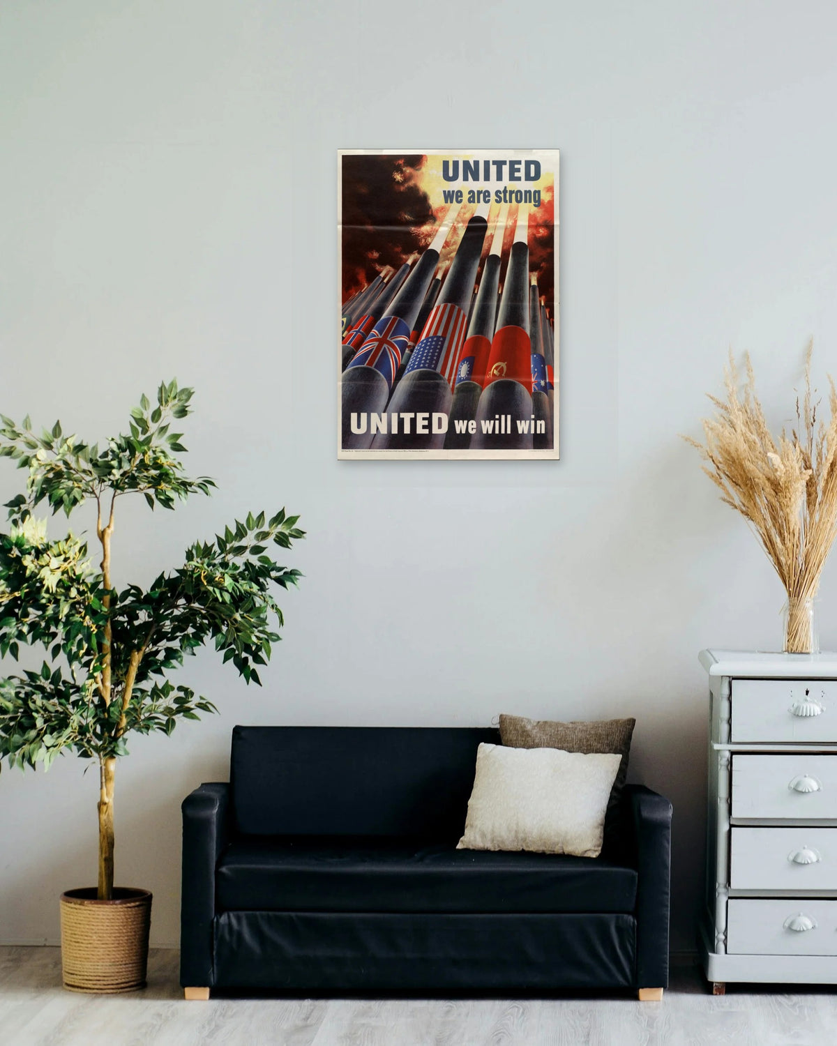 "United We Are Strong – United We Will Win" poster on a living room wall