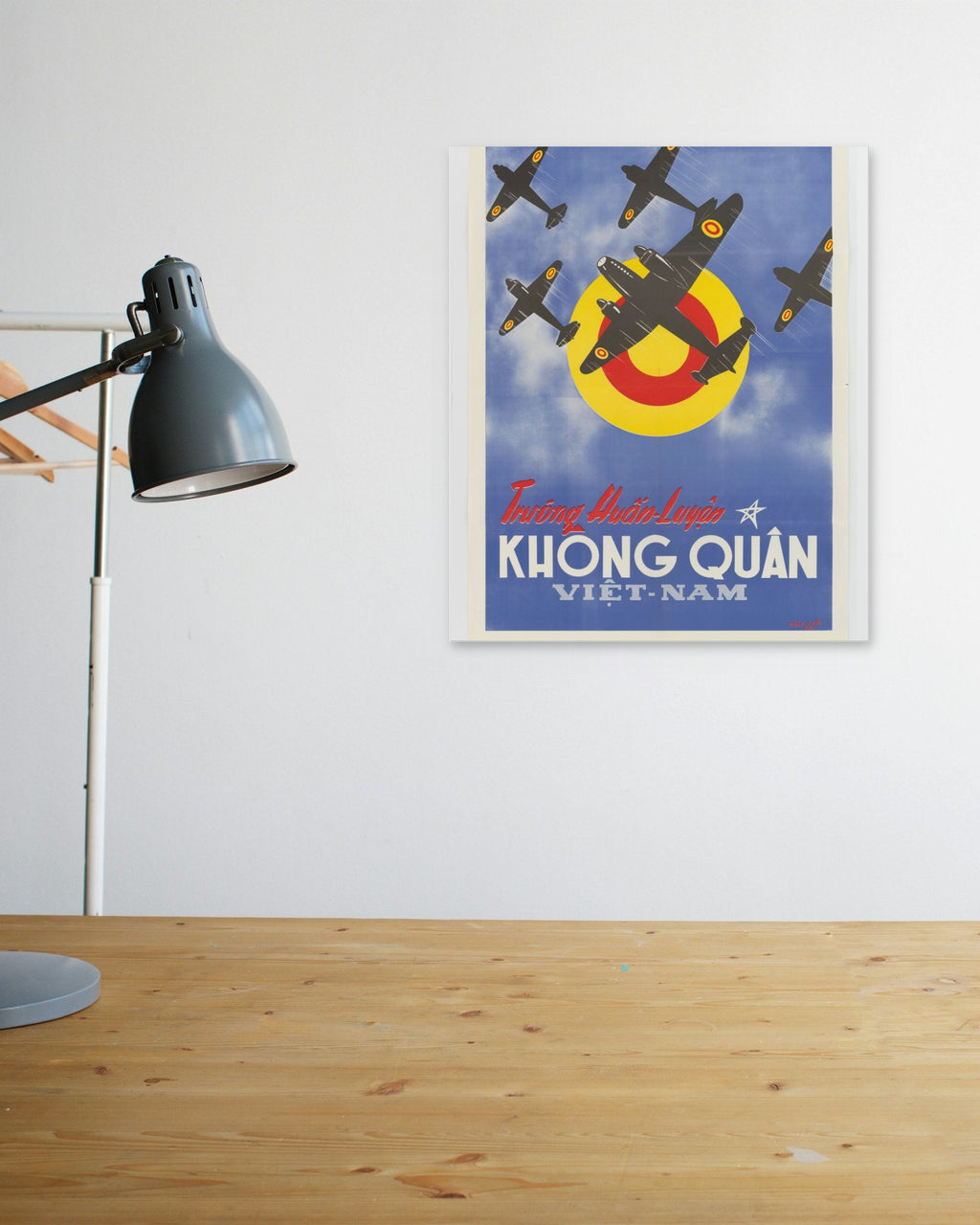 "Vietnam Air Force Training School" poster above a wooden desk