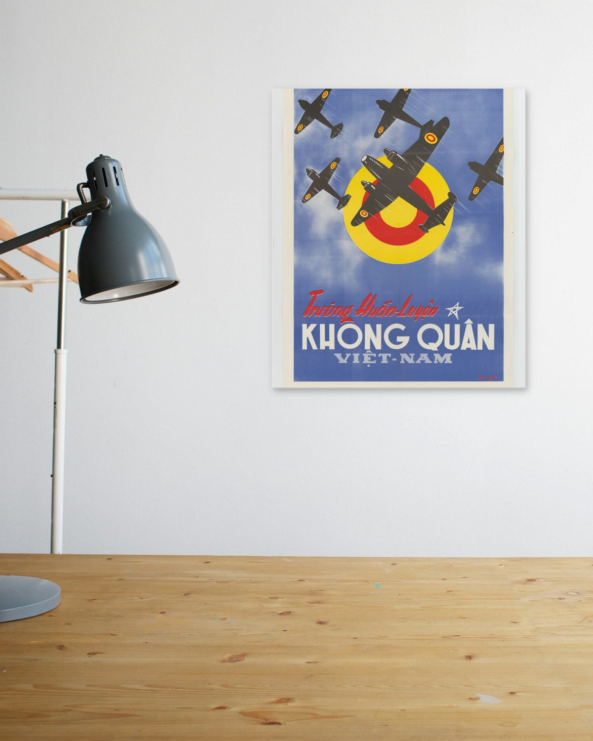 "Vietnam Air Force Training School" poster above a wooden desk