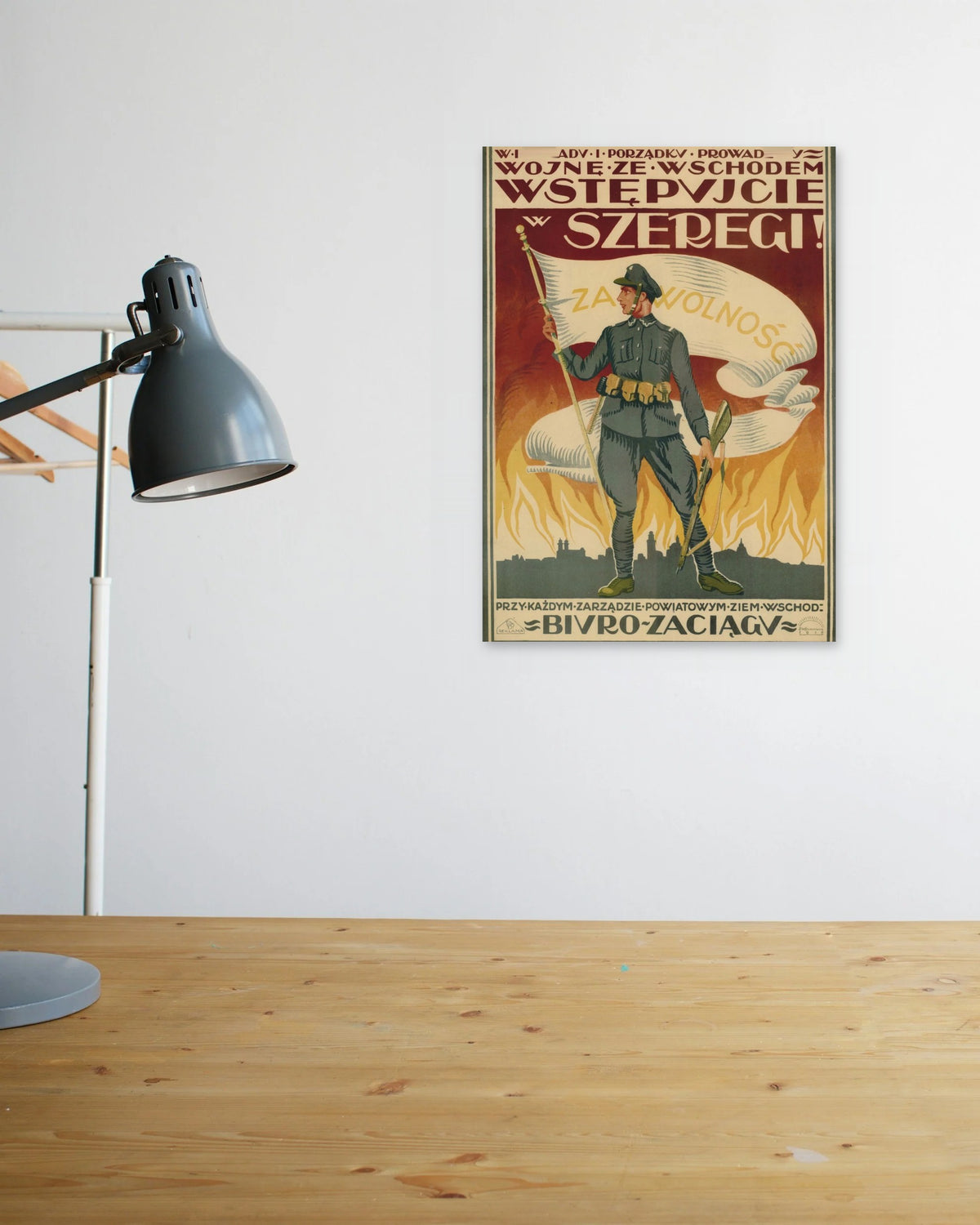 "W Imię Ładu i Porządku" poster above a wooden desk