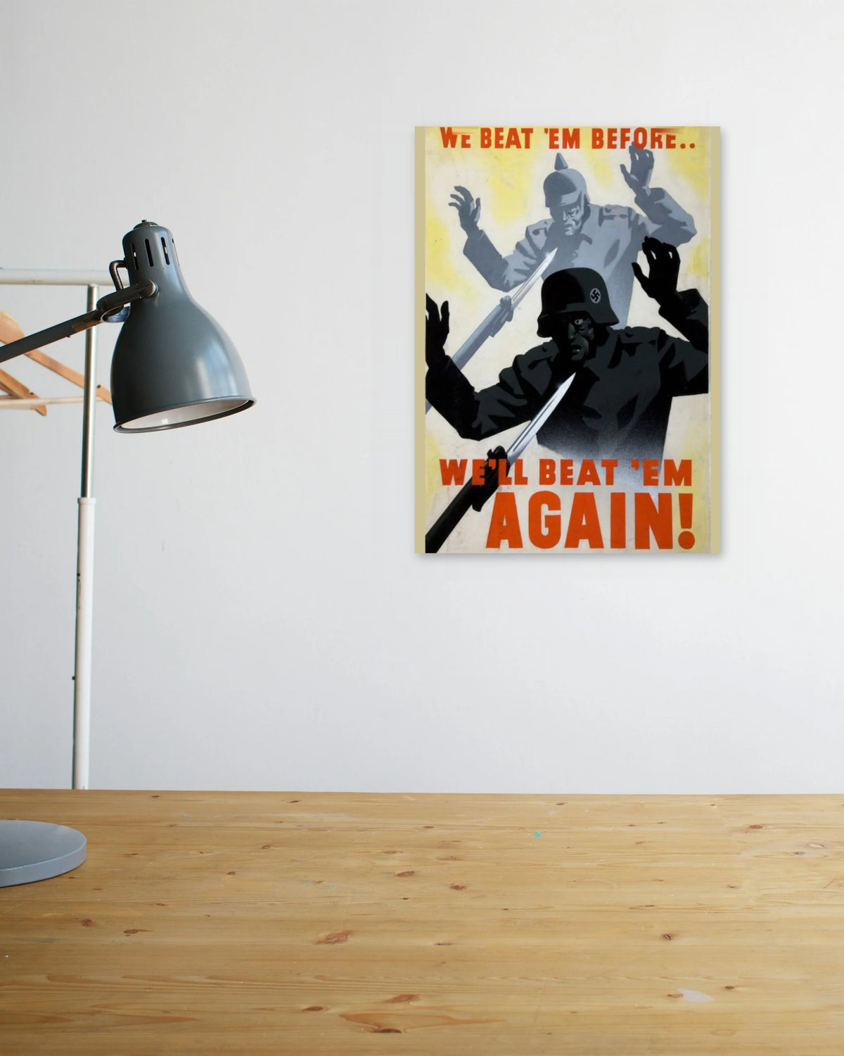 "We Beat 'em Before... We'll Beat 'em Again" poster above a wooden desk