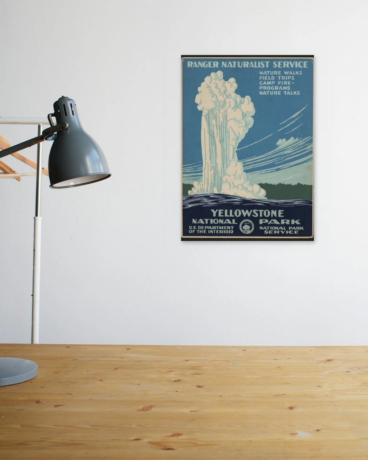 "Yellowstone National Park" poster above a wooden desk